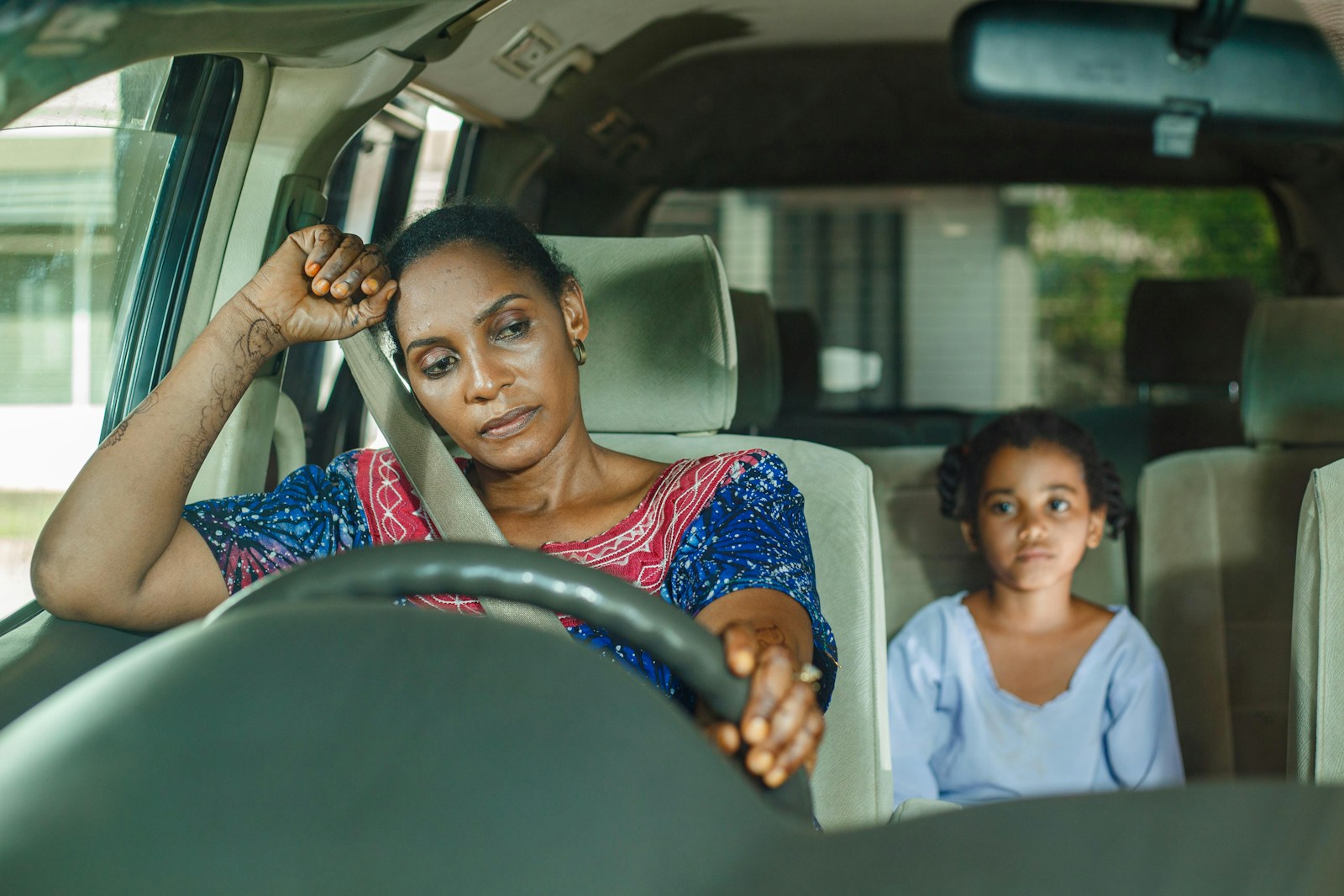 a woman and a child sitting in a car thinking about common problems with auto insurance claims